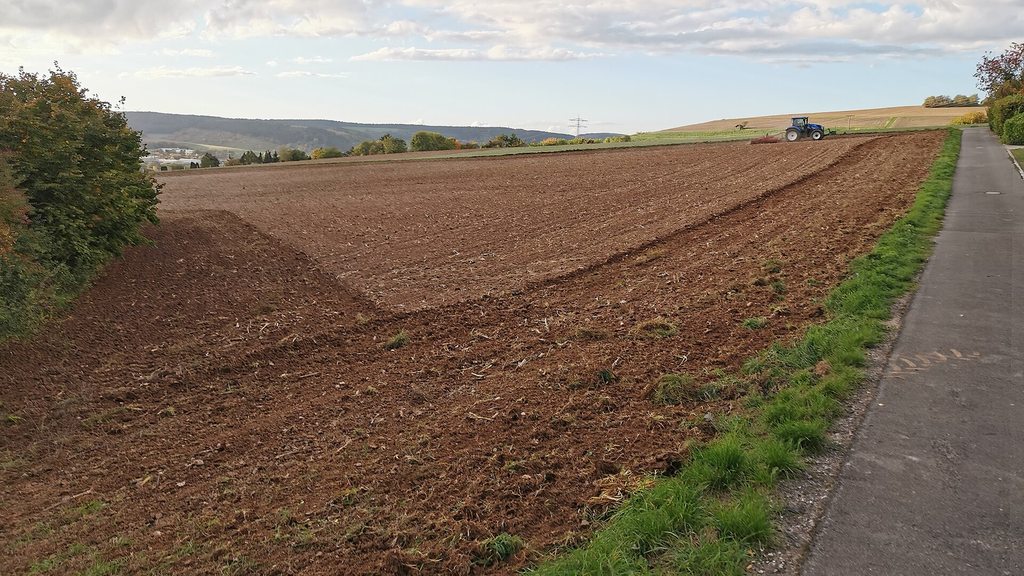 Frisch gepflügter Acker mit Traktor